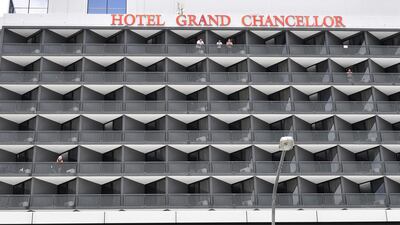 Hotel guests are seen on a balcony at the Hotel Grand Chancellor in Brisbane, Australia, as the Queensland government is shutting it down after six people staying there contracted the UK strain of coronavirus. EPA