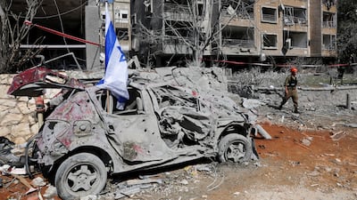 A rescue personnel walks next to a damaged vehicle in Ramat Gan, Israel. Reuters