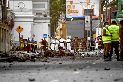 Sri Lankan priests look at the debris of a car after it explodes when police tried to defuse a bomb near St. Anthony's Shrine in Colombo on April 22, 2019, a day after the series of bomb blasts targeting churches and luxury hotels in Sri Lanka. AFP / Jewel SAMAD