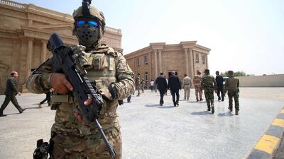 A member of the Iraqi security forces stands guard in front of the local government headquarters in Basra. Haidar Mohammed Ali / AFP