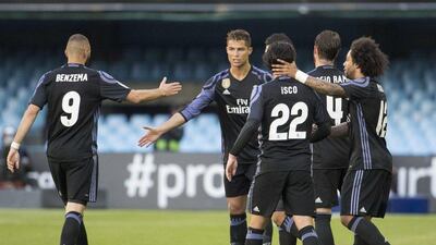 Cristiano Ronaldo is congratulated by teammates after scoring his first and Real Madrid's first goal in the 4-1 win over Celta Vigo on Wednesday night. Lalo R Villar / AP Photo