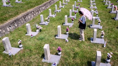 A woman visits a grave in the National Cemetery, in Seoul, as South Korea marks Memorial Day, which honours those who died during the 1950-53 Korean War and in other operations while serving their country. AFP