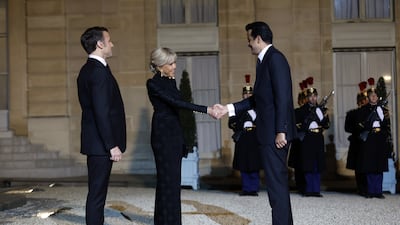 Ms Macron greets Sheikh Tamim as her husband watches on. EPA