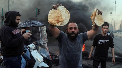 A demonstrator holds government subsidized bread during a protest in Beirut, Lebanon. Bloomberg