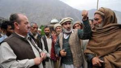 Residents of Juttal village confront an official over the suitability of relief efforts. Villagers are upset about a lack of information.