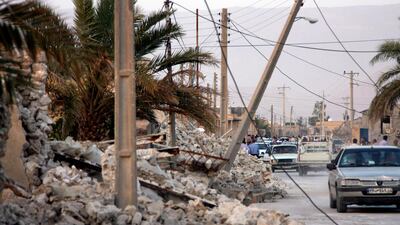 Vehicles make their way along structures destroyed by the earthquake. AP Photo/ Mohammad Fatemi