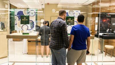 A man and a boy look into Rolex's store at Mall of the Emirates. Reem Mohammed / The National