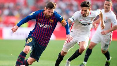 Messi looks to make a break as he challenged by Sevilla. AP
