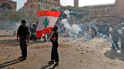 A Lebanese protester waves the national flag during clashes with security forces in downtown Beirut. AFP