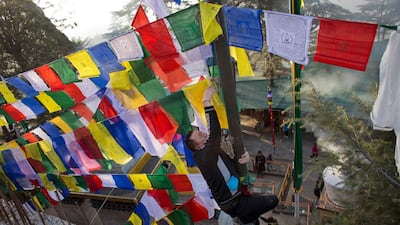 An exiled Tibetan ties multicoloured prayer flags called lungta, or wind horse, on a high pole on the third day of the Tibetan New Year in Dharmsala, India. Tibetans believe that the prayers inscribed on these flags representing the five elements, earth, fire, water, space and air, are spread on wind. Ashwini Bhatia / AP Photo