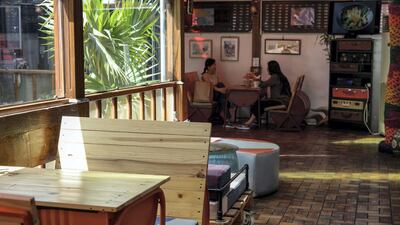 Old barrels and tyres fashioned into tables, wooden slats transformed into benches, vintage suitcases placed one atop the other, and coloured ceiling panels that let light through, reflecting a rainbow on the floor. Khushnum Bhandari / The National