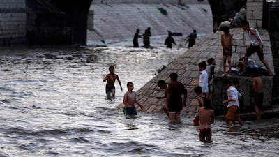 Yemeni boys enjoy rainwater at a flooded street following heavy rainfall in the Old City of Sanaa, Yemen. EPA