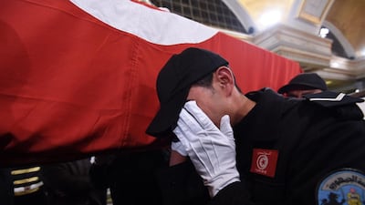A Tunisian policeman mourns as he carries the coffin of a member of the presidential guards, who was killed in a suicide attack on a bus in central Tunis the previous day. Fethi Belaid/AFP Photo