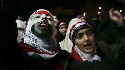 Syrian women living in Jordan paint their faces with the Syrian flag and shout slogans against President Bashar al Assad during a demonstration in front of the Syrian embassy in Amman.