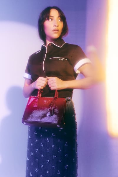 Cotton polo shirt; embellished pinstripe wool midi skirt; and Galleria leather bag, all from Prada