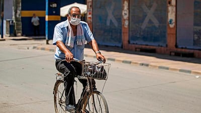 A man rides a bicycle along an empty street in the Kurdish-majority city of Qamishli in Syria. AFP