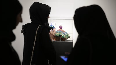 Visitors take a look at ‘Thehban’, a custom-designed miniature mannequin, at the gallery in Abu Dhabi.
