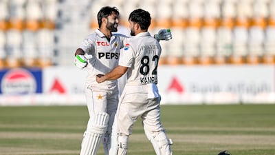 Pakistan's Kamran Ghulam, right, celebrates with teammate Mohammad Rizwan after scoring a century on his debut on the first day of the second Test against England at Multan Cricket Stadium on October 15, 2024. AFP
