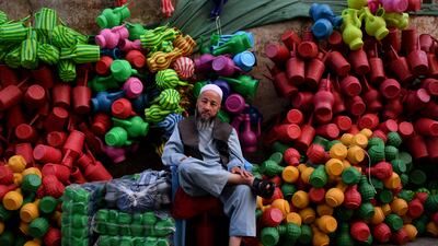A vendor awaits customers at his stall selling plastic cans in a market in Mazar-i-Sharif, Afghanistan. AFP