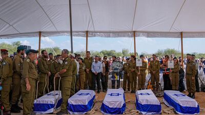 Mourners gather around the five coffins of the Kotz family during their funeral in Gan Yavne. AP