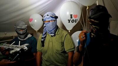 Protesters in Gaza calling themselves the "night confusion units" hold incendiary devices attached to balloons to be launched towards Israel.