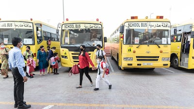 Teachers and staff members welcome pupils on their first day back at school.