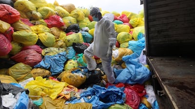 A worker stands over bags of medical waste at a hospital in Mumbai. Getty