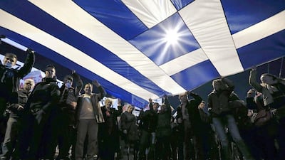 Protesters hold a giant Greek national flag during an anti-austerity and pro-government demonstration in front of the parliament in Athens on February 15, 2015. Alkis Konstantinidis / Reuters