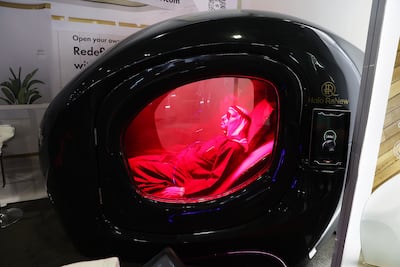 Visitors try out the Longevity Capsule by HaloRenew on the opening day of Arab Health. Pawan Singh / The National