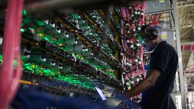 A technician monitors cryptocurrency mining rigs at a facility in Quebec, Canada. Bloomberg