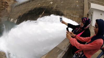 Omanis take pictures of the spillway in the Wadi Dayqah Dam, east Muscat. The sultanate was hit by heavy rains from tropical storm Ashobaa. AFP PHOTO