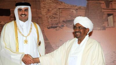 The Emir of Qatar, Sheikh Tamim bin Hamad Al Thani, left, greets the Sudanese president Omar Al Bashir during a visit to Khartoum on April 2, 2104. Ashraf Shazly / AFP