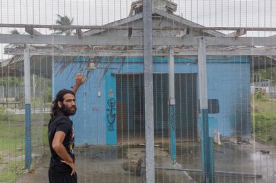 Boochani stands outside the abandoned naval base on Manus Island, where he and other asylum seekers were locked up for the first three years. Getty.