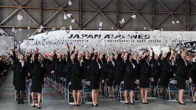 New employees of Japan Airlines toss paper planes during their company orientation ceremony at a JAL hanger in Tokyo. Kimikasa Mayama / EPA