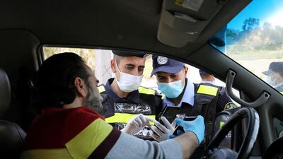 Jordanian policemen check the electronic pass of a driver at a checkpoint in Amman, Jordan. Reuters