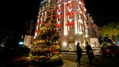 Syrians stand next to a christmas tree in Damascus' Sabaa Bahrat Square. AFP