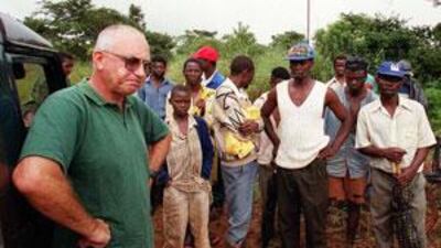 Zimbabwean farmer Andreo Malus, left, is pictured in 2000 on his property north of Harare at the start of Robert Mugabe's land grab scheme.