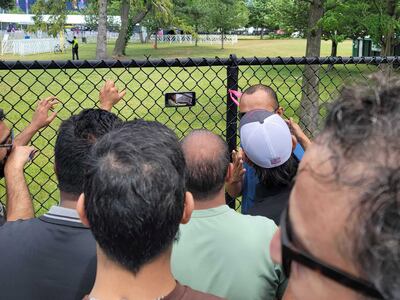 Fans catch the action on phone outside the Nassau County stadium in New York.