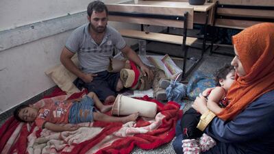 Palestinian Achmed Atta from Beit Lahiya in northern Gaza with his family on the floor of a classroom where they slept as they take shelter at the UNRWA New Gaza Boys Prep school in the Refugee Beach Camp on July 14. Heidi Levine for The National