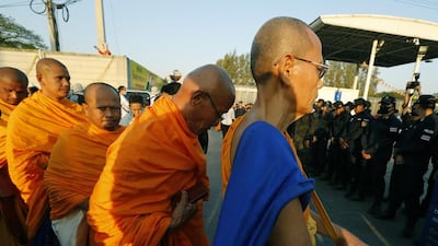 Thai Buddhist monks stand across from police officers as law enforcement and military authorities make preperations to raid the Dhammakaya Temple in Pathum Thani province, on February 16, 2017 to arrest Dhammakaya Temple abbot Phra Dhammachayo, who is charged with money laundering and the embezzlement of funds. Narong Sangnak / EPA