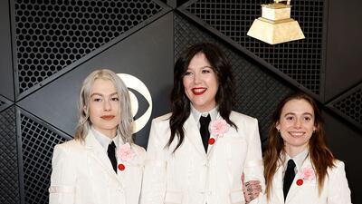 Phoebe Bridgers, Lucy Dacus and Julien Baker of Boygenius wear matching Thom Browne suits with red Artists For Ceasefire pins. Getty Images