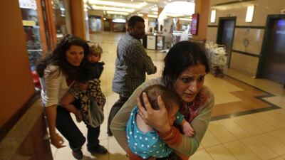 Women carrying children run for safety as armed police hunt gunmen who went on a shooting spree in Nairobi’s Westgate shopping centre. Goran Tomasevic / Reuters