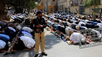 A police officer stands guard as people offer Friday prayers in Karachi, Pakistan. Reuters