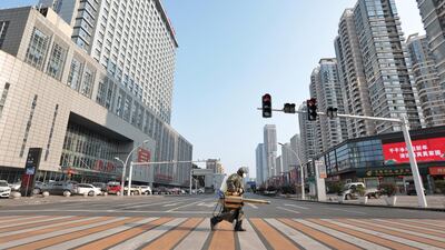 A worker with sanitisng equipment crosses the road in front of a hospital in Yichang city of Hubei, China. Reuters