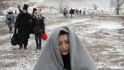 Migrants walk through a frozen field on January 18, 2016, after crossing the border from Macedonia, near the village of Miratovac, Serbia. Marko Djurica / Reuters