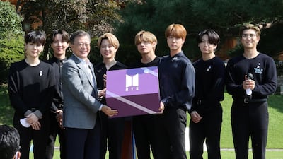 South Korean President Moon Jae-in and members of K-Pop boyband BTS pose for photographs with a gift given by BTS during Youth Day at the Presidential Blue House in Seoul, South Korea, September 19, 2020. Yonhap via Reuters