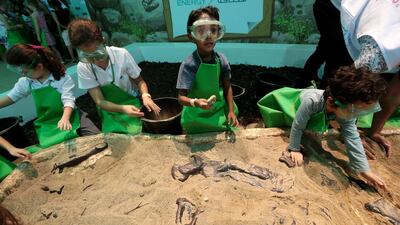 Youngsters get a hands-on experience of science as they take part in the ‘dig a dinosaur’ activity during the opening day of the Abu Dhabi Science Festival at Mushrif Central Park. The festival runs until November 22. Christopher Pike / The National