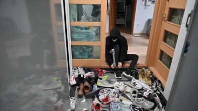 Blitzers member Choi Gyeong-seok putting on his shoes to go to a gym in the band's shared house in Seoul. AFP