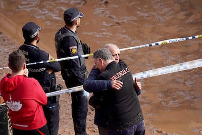 Residents wait for news of their relatives trapped during the floods in Valencia. AP