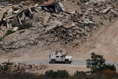 An armoured vehicle of Unifil, the UN peacekeeping force, drives past destroyed buildings in southern Lebanon. AFP